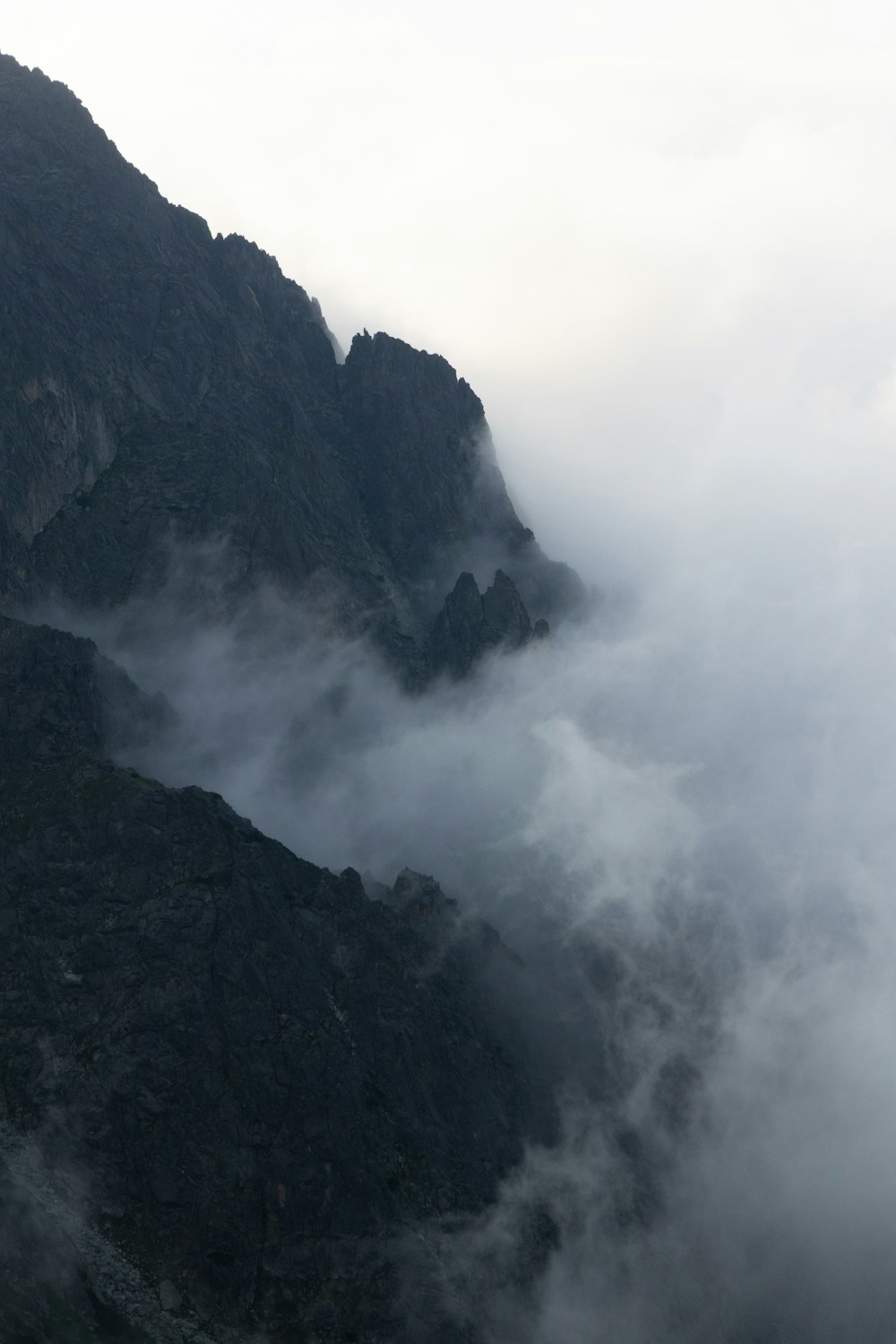 a very tall mountain covered in fog and clouds