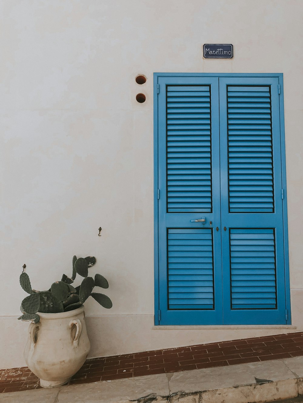 흰 벽 옆에 파란 나무로 되는 문