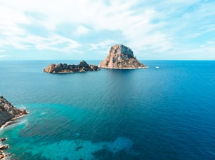 gray and brown rock formation on blue sea under blue sky during daytime