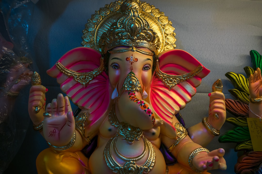 gold and pink hindu deity figurine