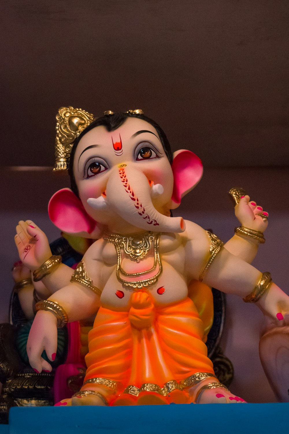 Figura de deidad hindú dorada y rosa