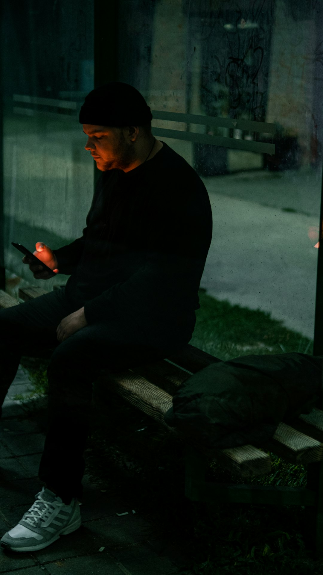 man in black sweater sitting on bench