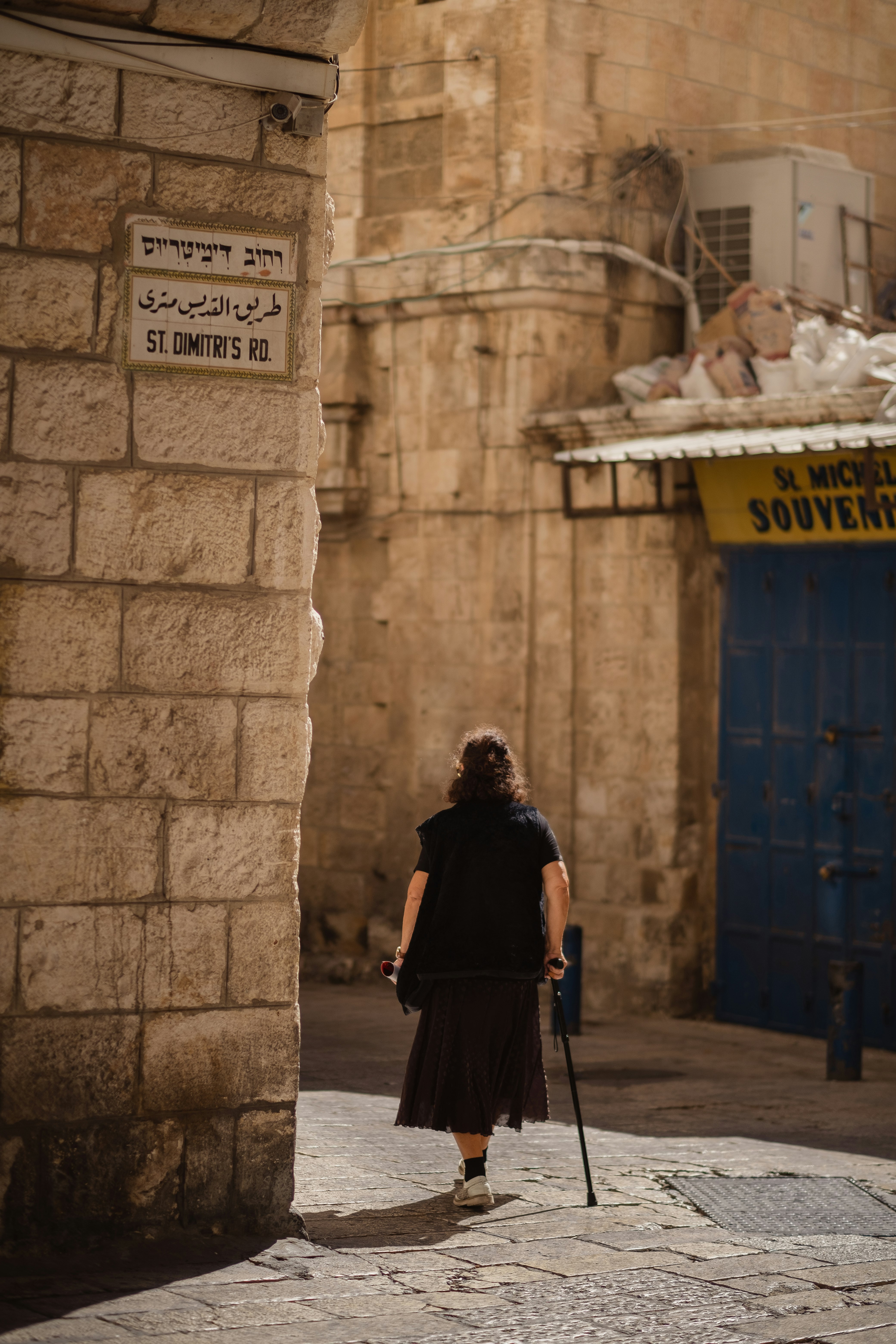 woman in black jacket walking on sidewalk during daytime