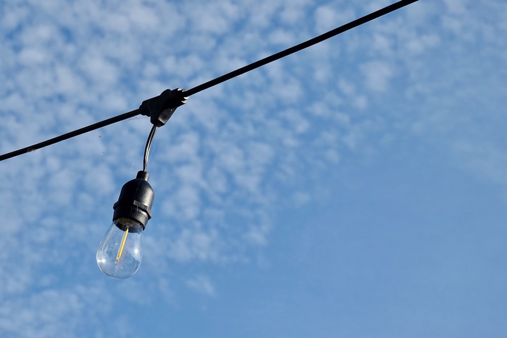 lampadina nera sotto il cielo blu durante il giorno