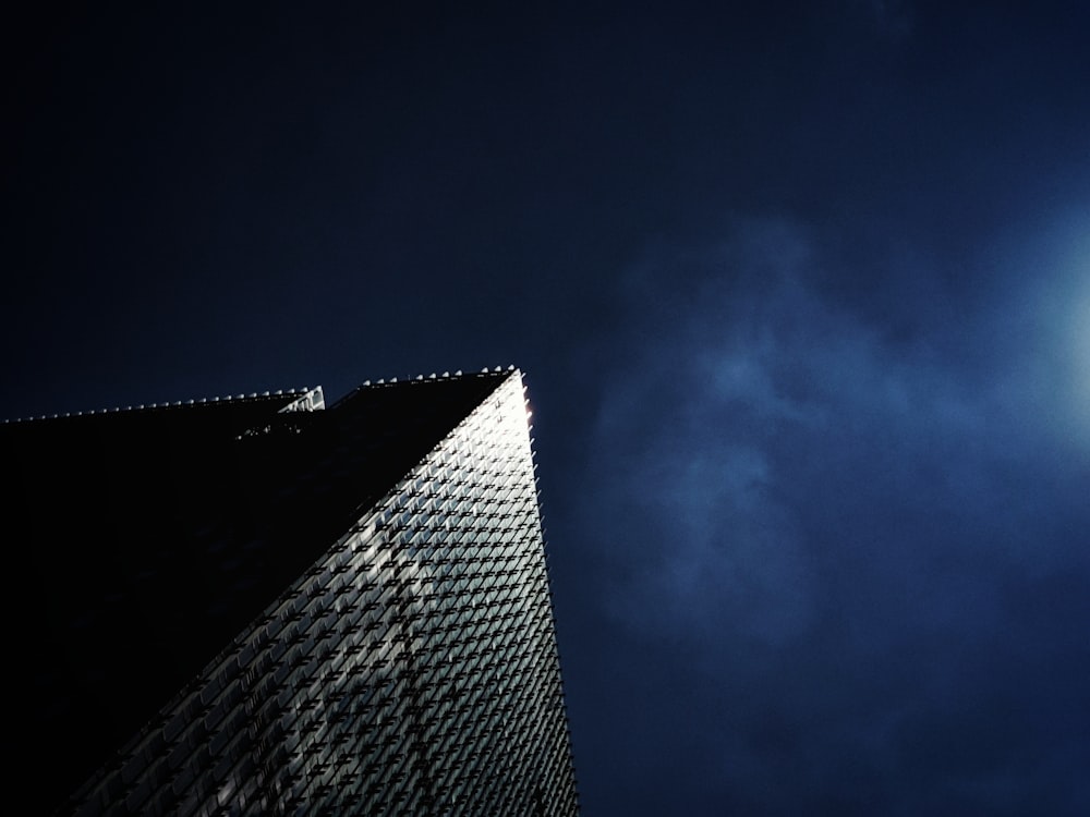 Un edificio muy alto con una luna muy brillante en el cielo