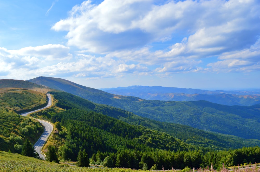 a scenic view of a winding road in the mountains