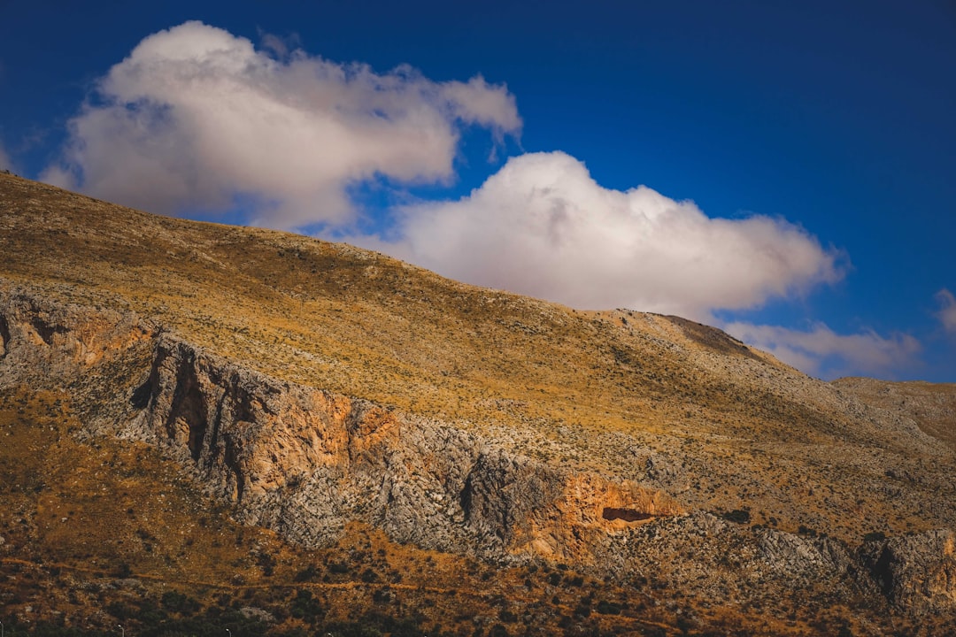 brown and green mountain under blue sky and white clouds during daytime