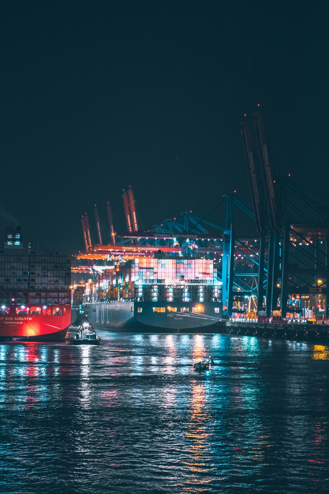 red and white cargo ship on dock during night time