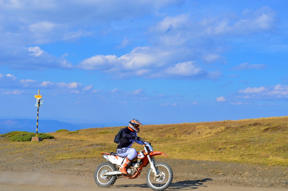 a man riding a dirt bike on a dirt road