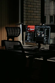 black flat screen computer monitor on black wooden desk