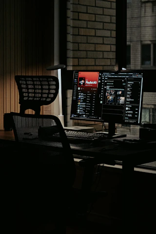 black flat screen computer monitor on black wooden desk