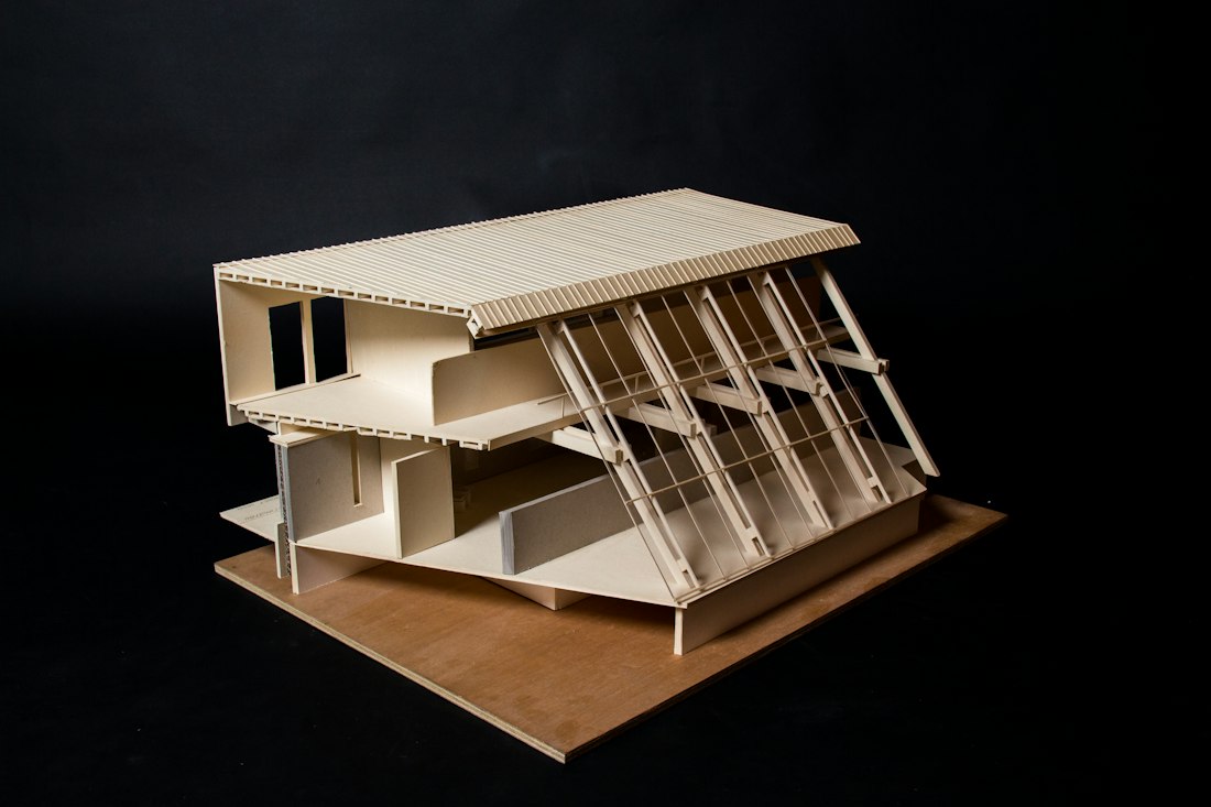 Maquete arquitetônica em madeira sobre fundo escuro