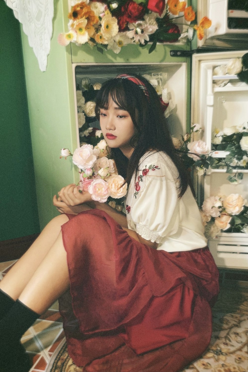 girl in white long sleeve shirt and red skirt sitting on red chair