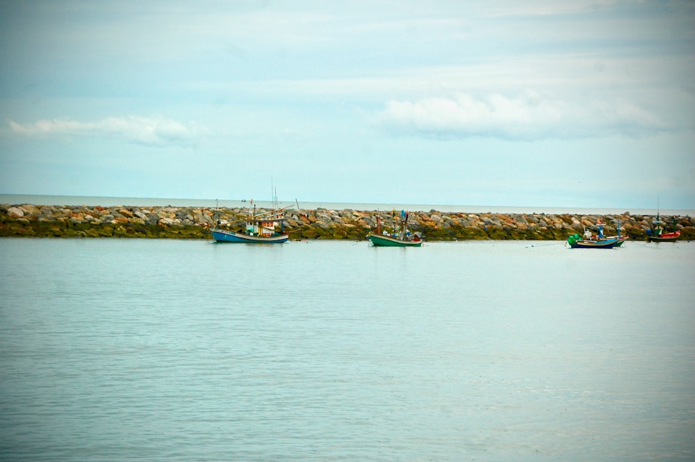 white and blue boat on sea under white clouds during daytime