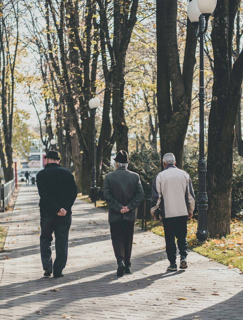 man in white dress shirt and black pants walking on sidewalk during daytime