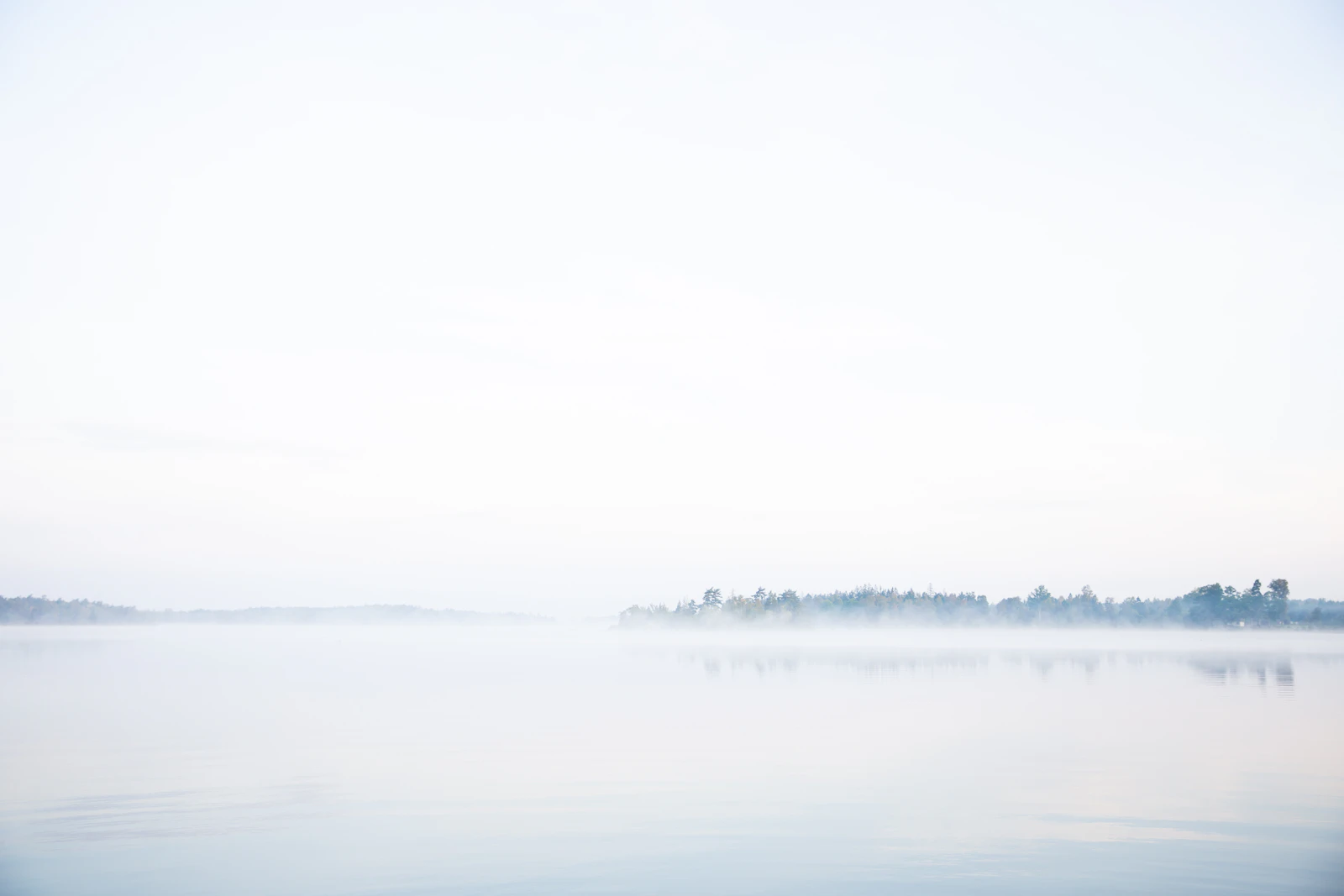 A still, misty lake at dawn