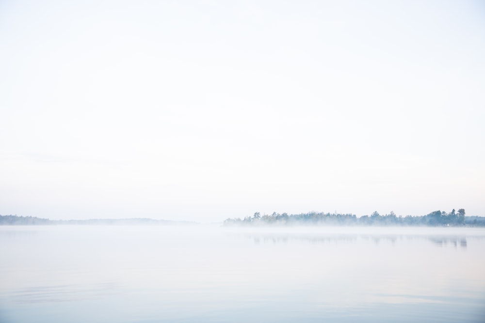 body of water under white sky during daytime