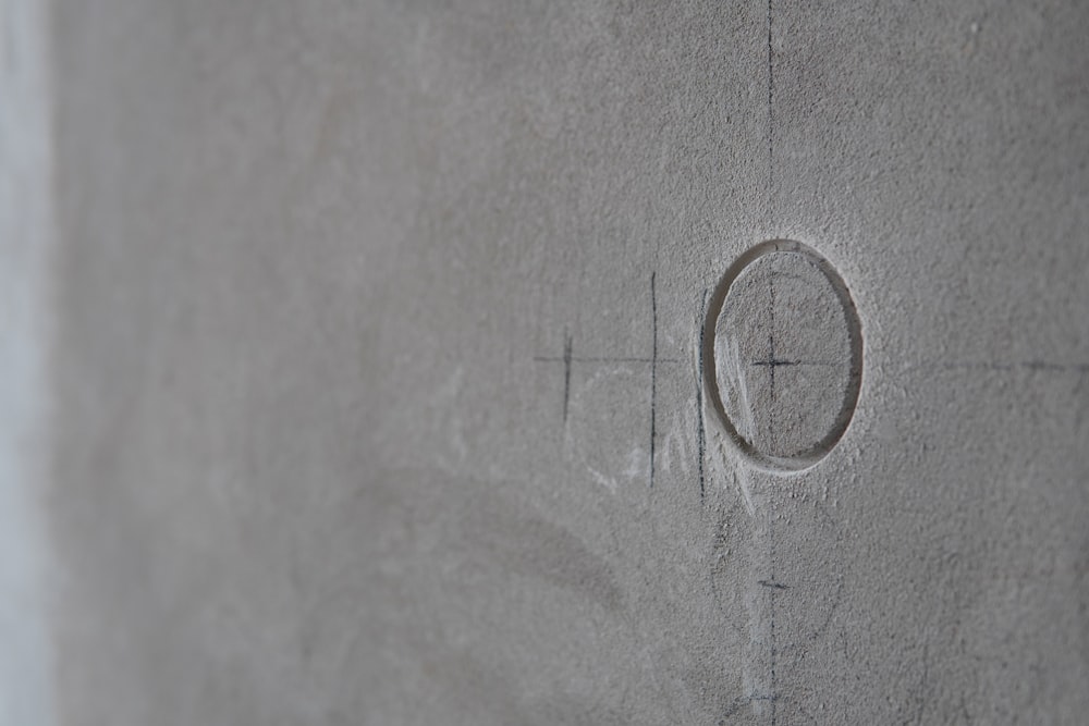 a close up of a cement wall with a cross on it