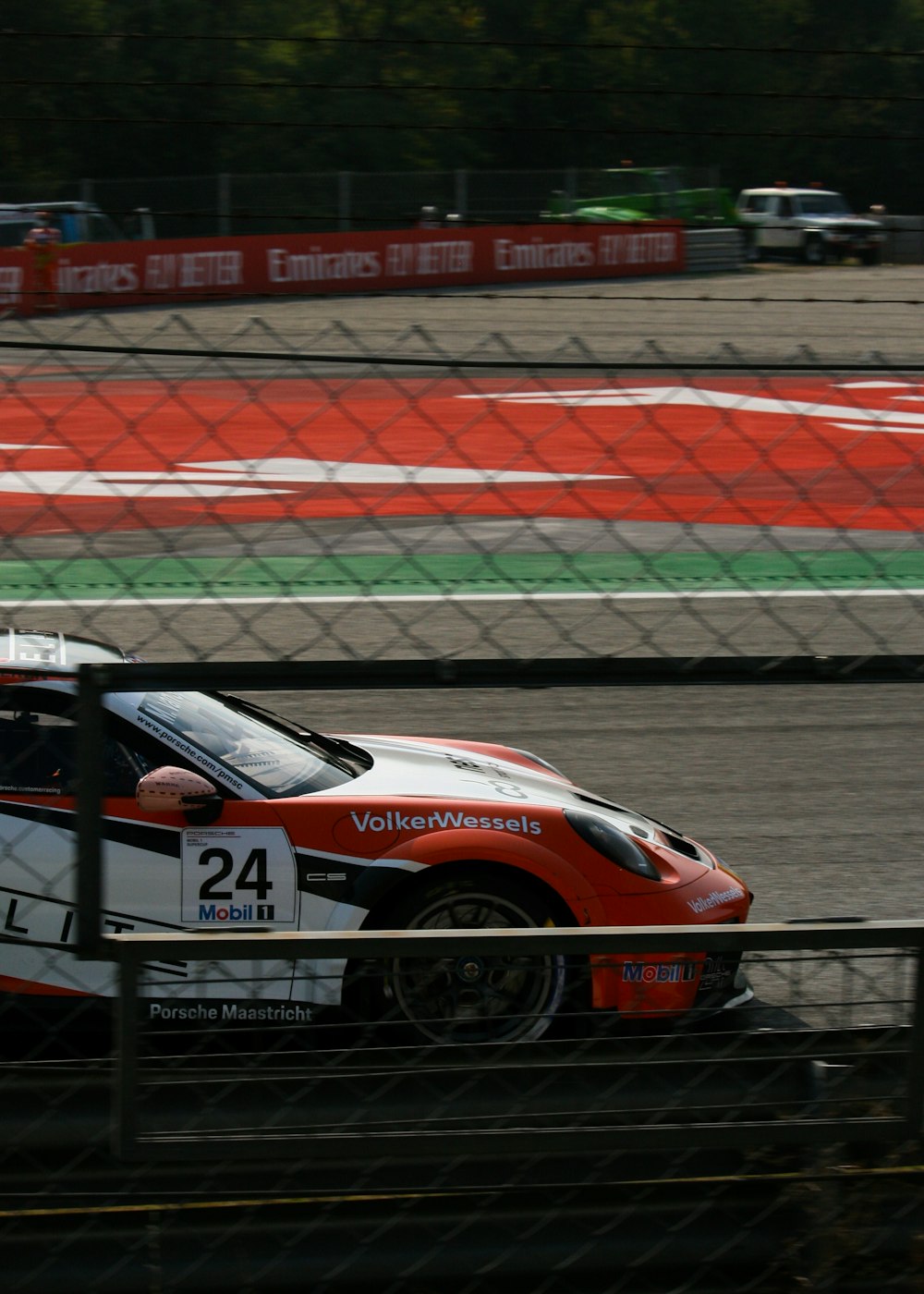 a red and white car driving on a race track