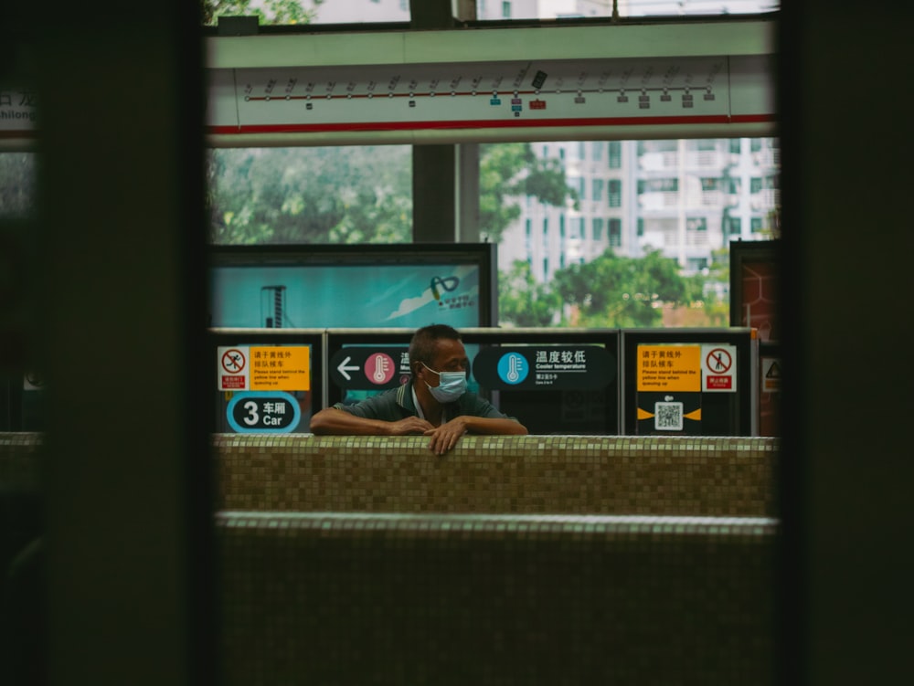 woman in blue t-shirt sitting on window