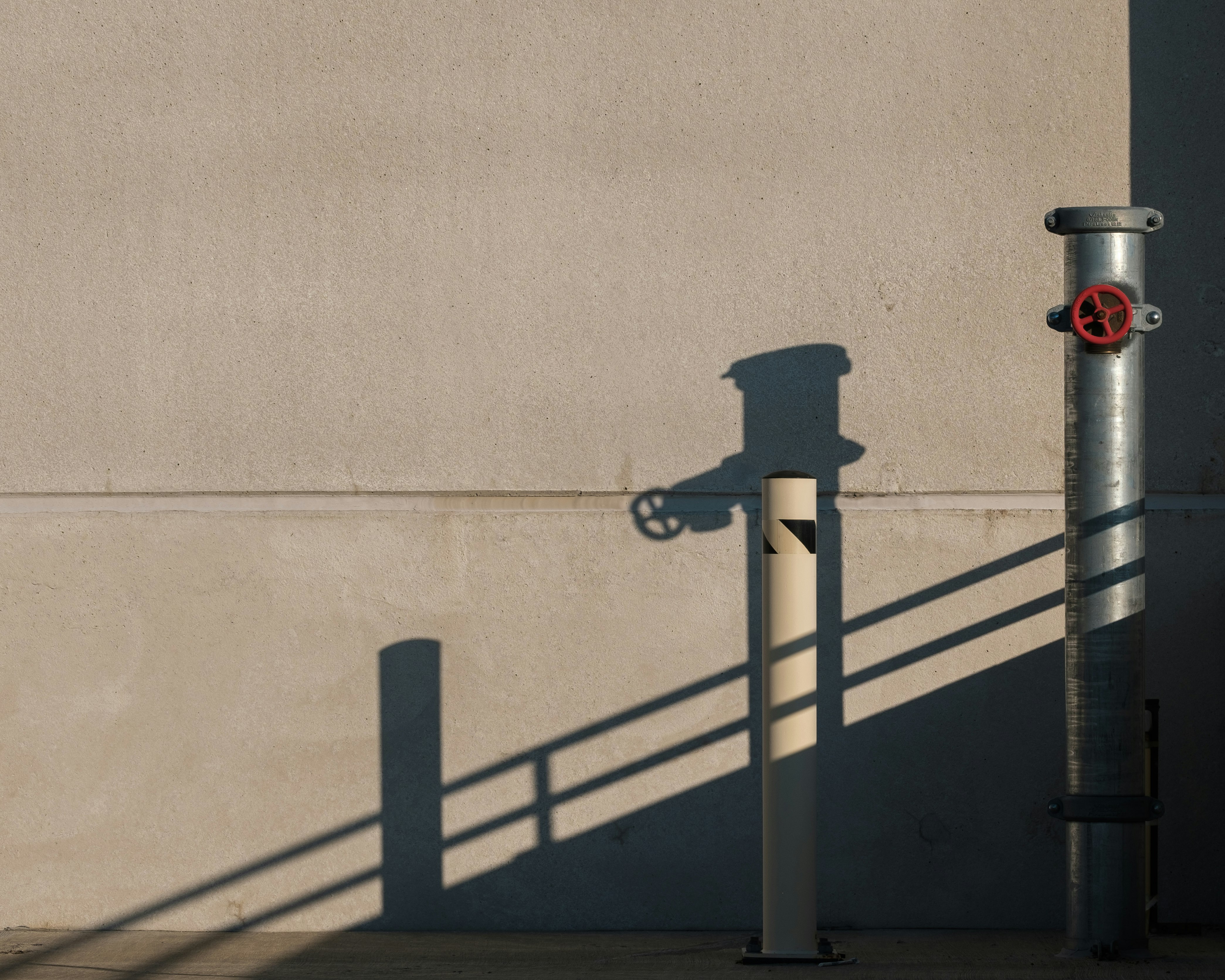 black metal pipe near white wall