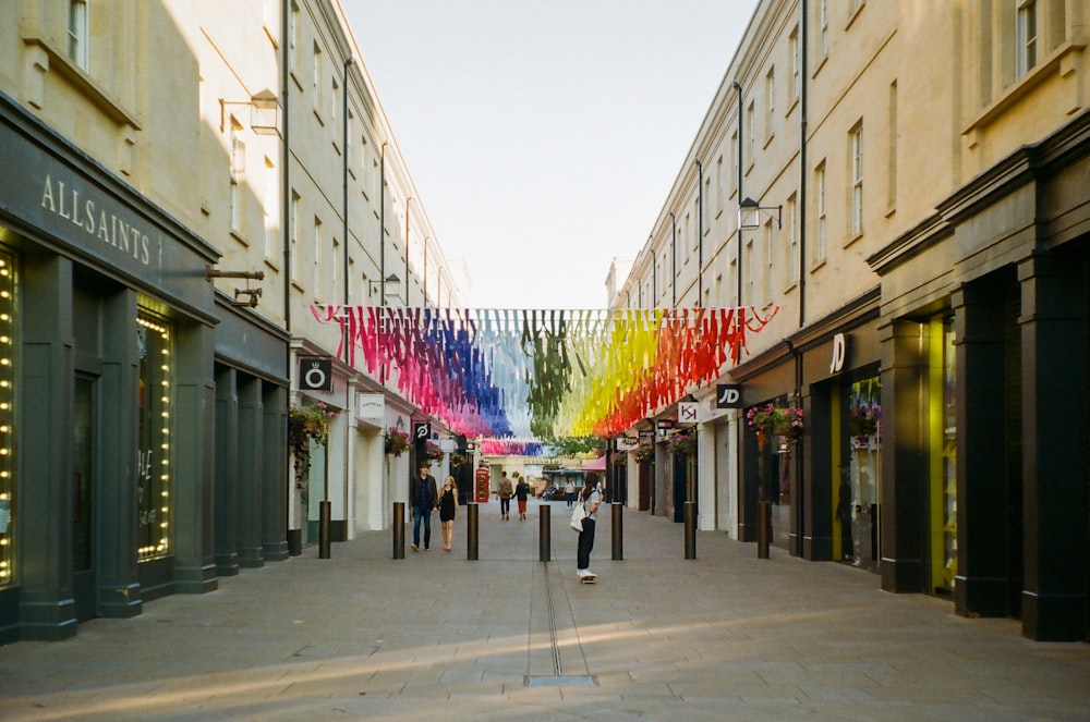 a city street with a rainbow flag hanging from the side of buildings