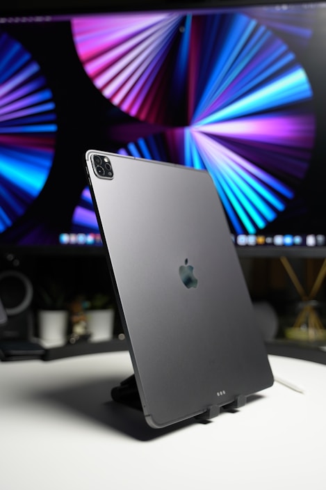 An Apple tablet surrounded by work materials on a stylish desk.