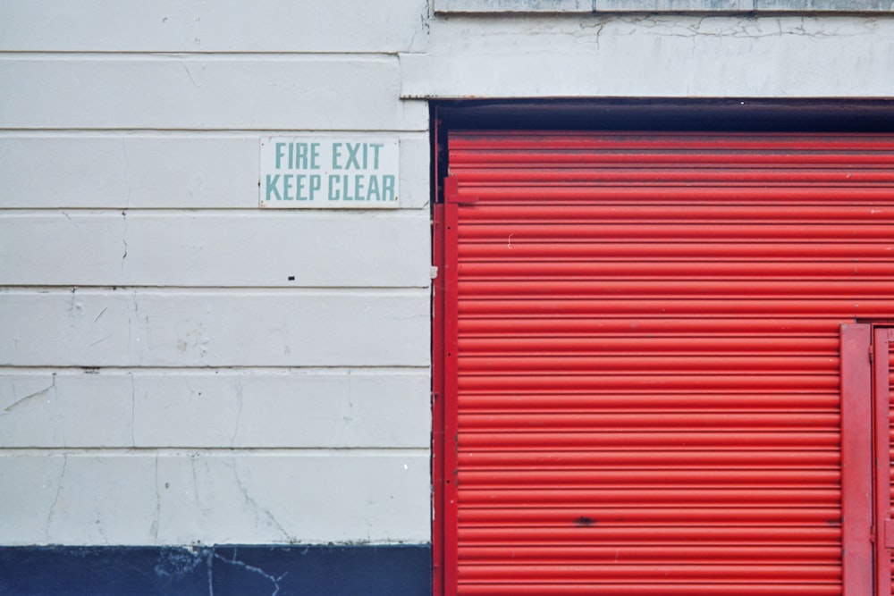 a red fire hydrant sitting next to a red garage door