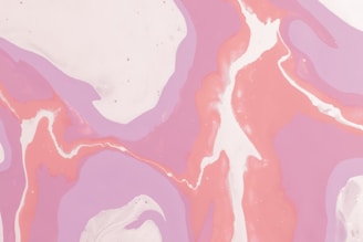 Abstract swirls of pastel pink, purple, and white create a flowing, marbled pattern. The colors blend seamlessly, forming a fluid and organic design reminiscent of liquid or smoke.