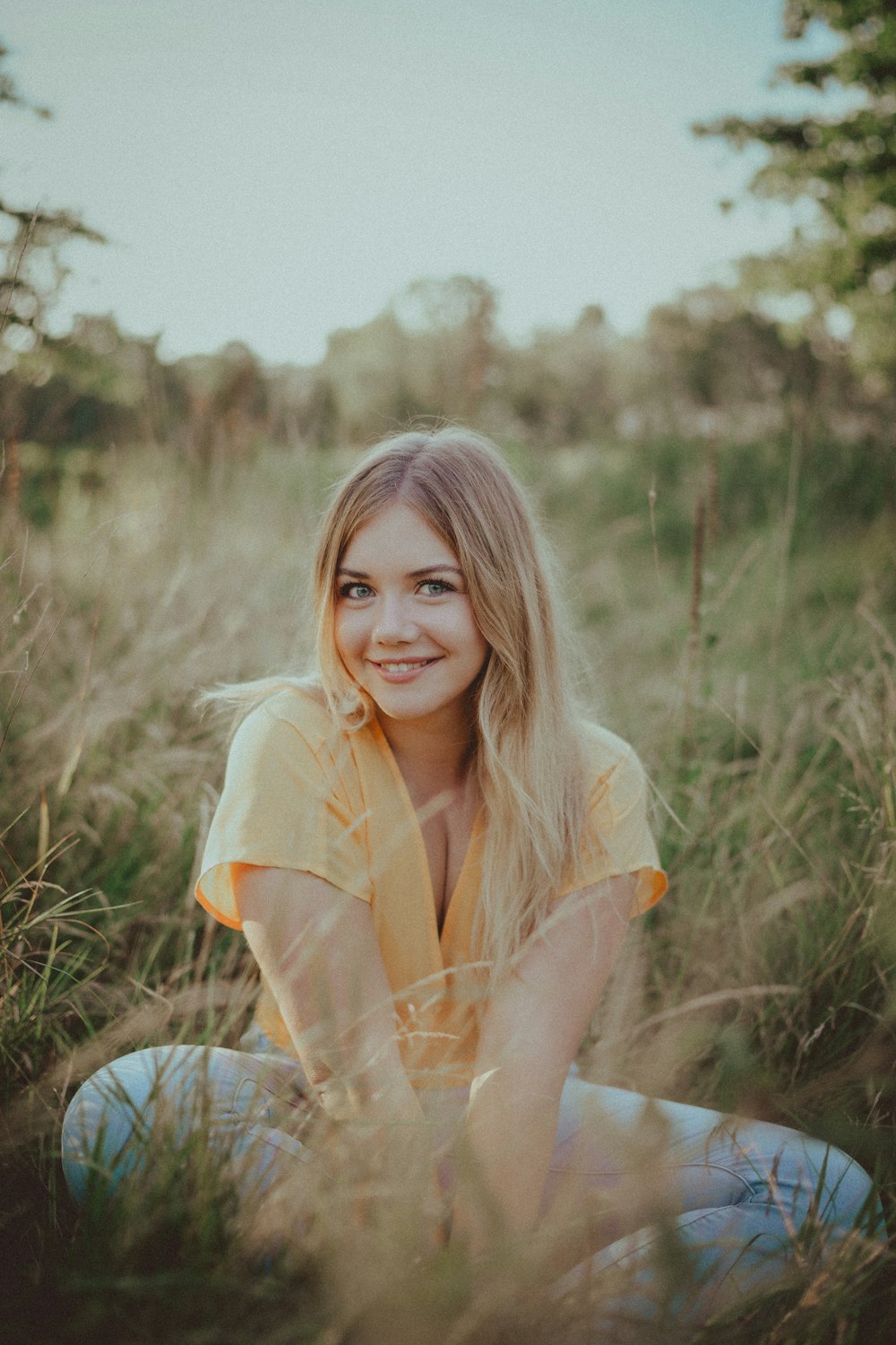 woman in yellow shirt sitting on brown wooden chair