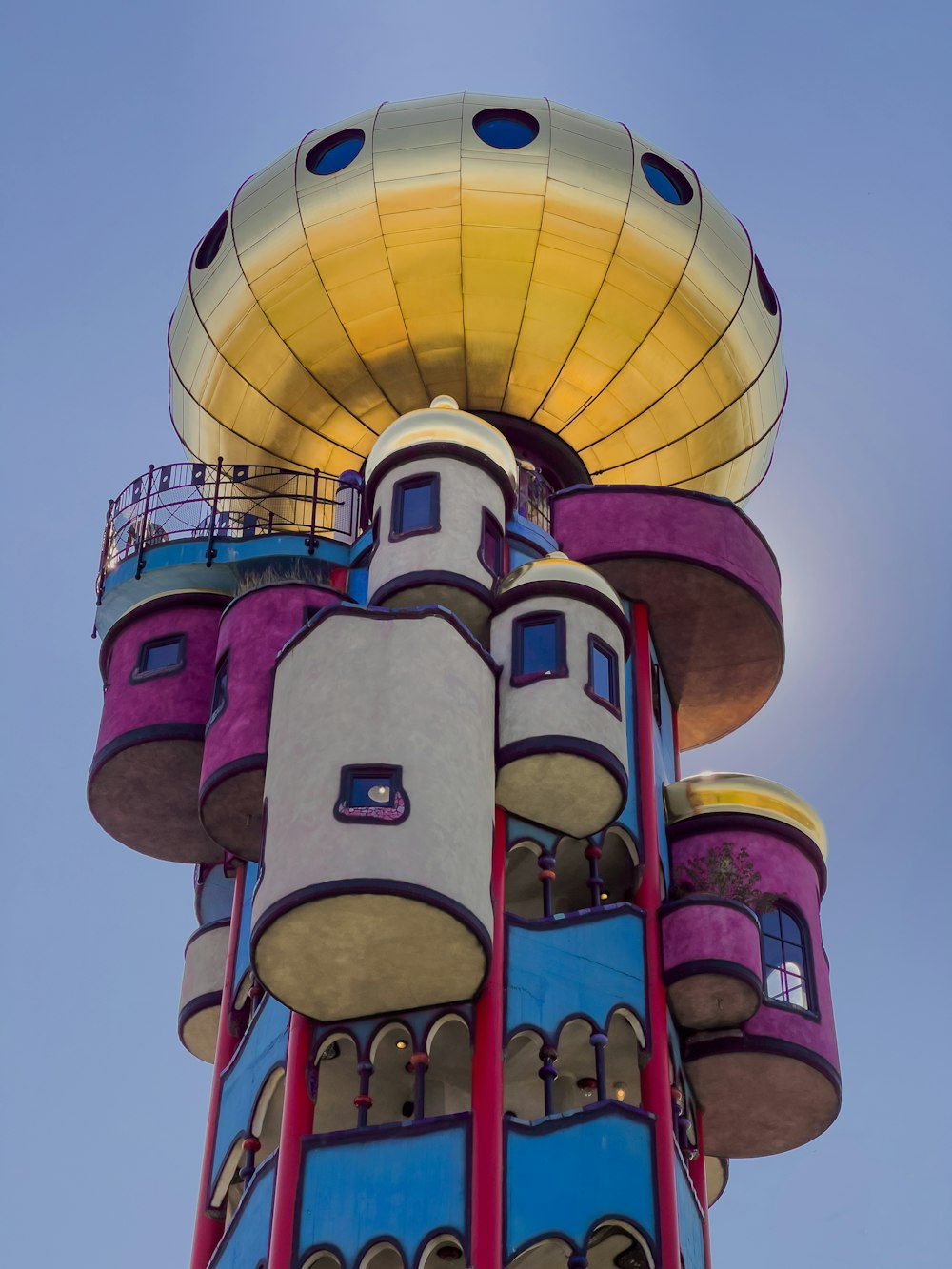 una torre molto alta con una struttura molto colorata in cima