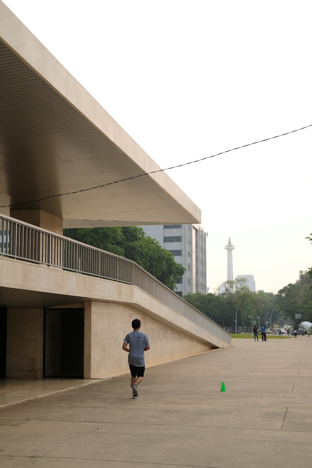 a man running down a sidewalk next to a building