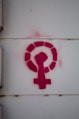 a red feminist logo on a white wall