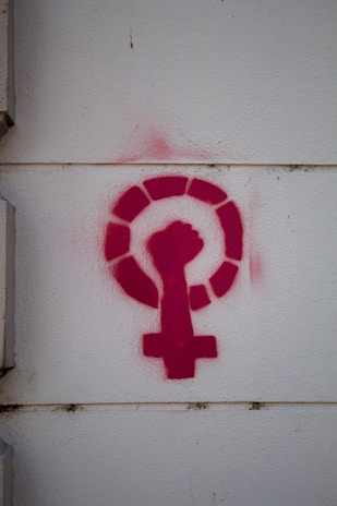 a red feminist logo on a white wall