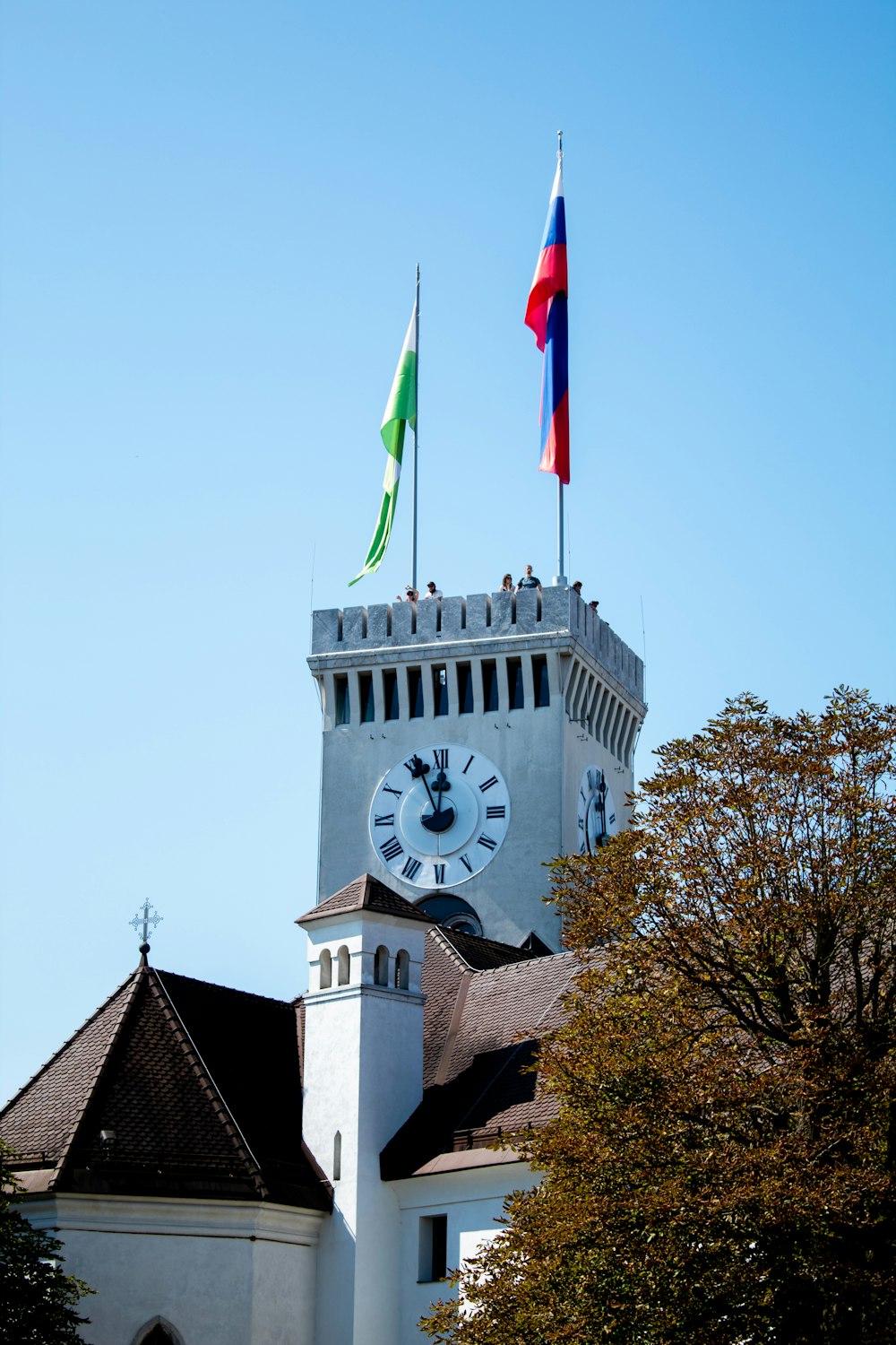 ein Uhrturm mit zwei Fahnen darauf