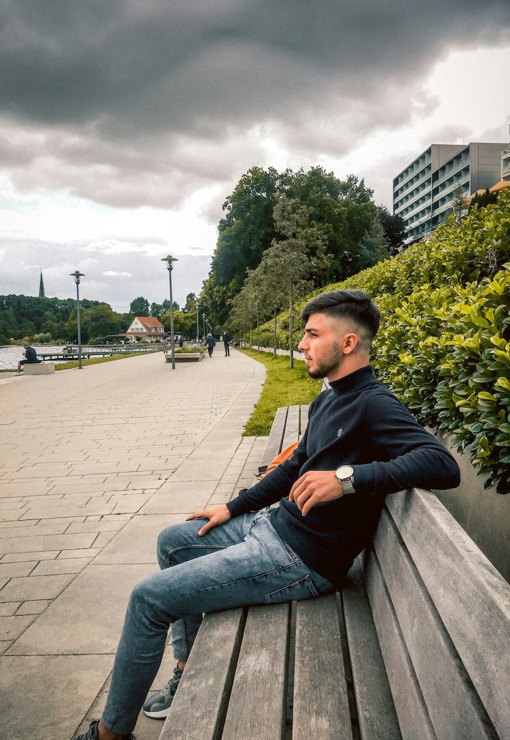 a man is sitting on a wooden bench