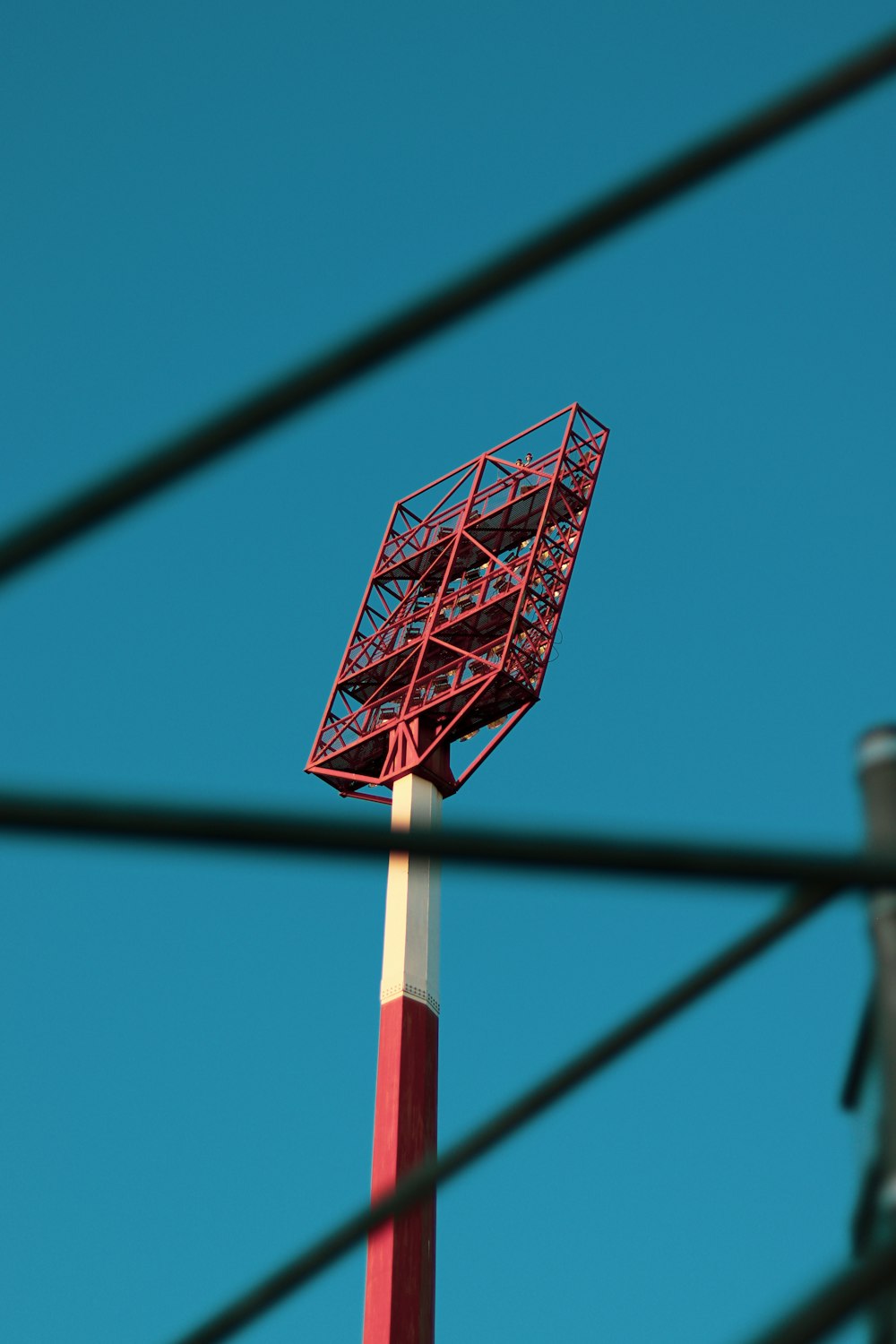 Una torre roja y blanca con un cielo azul en el fondo