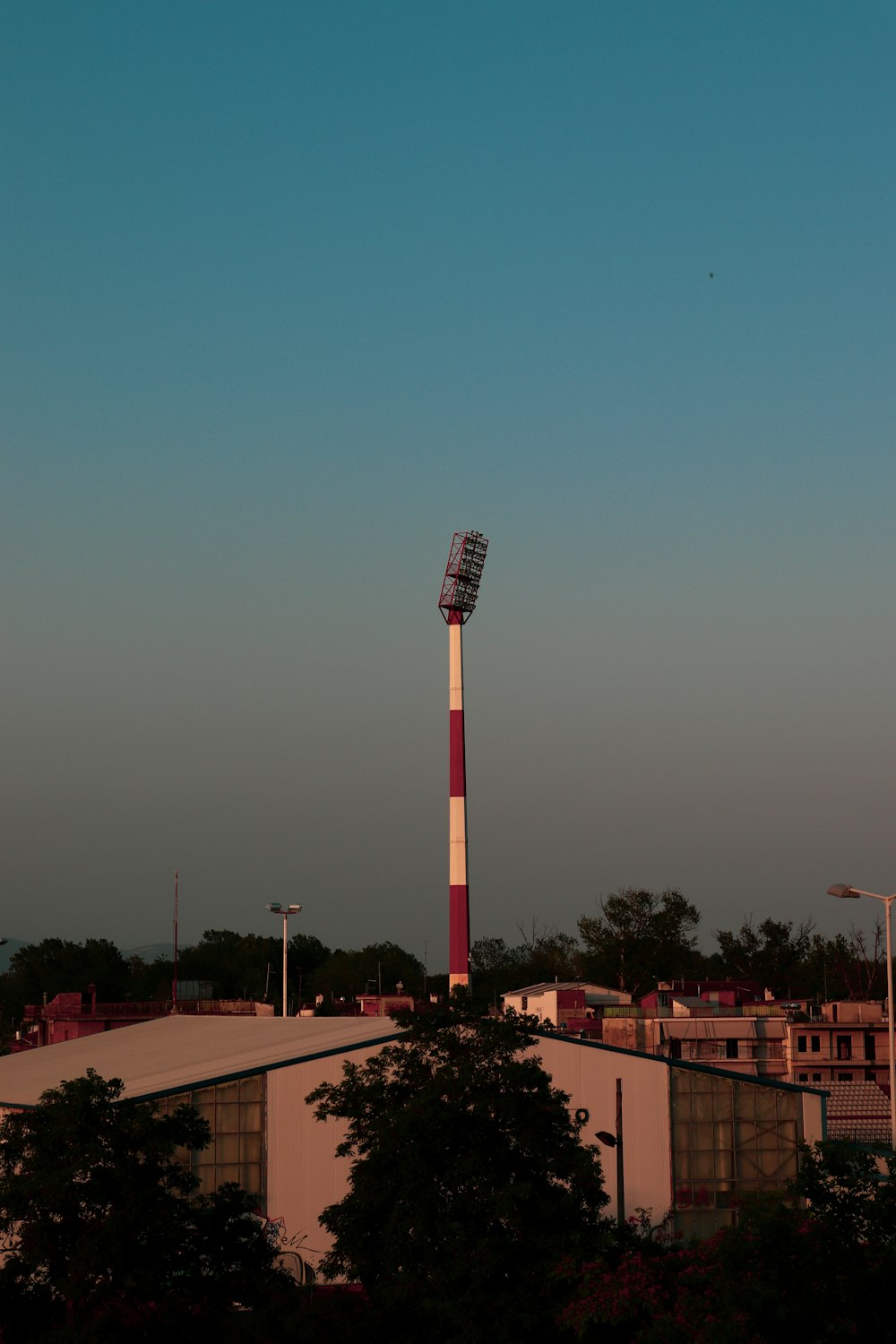 a tall red and white tower with a sky background