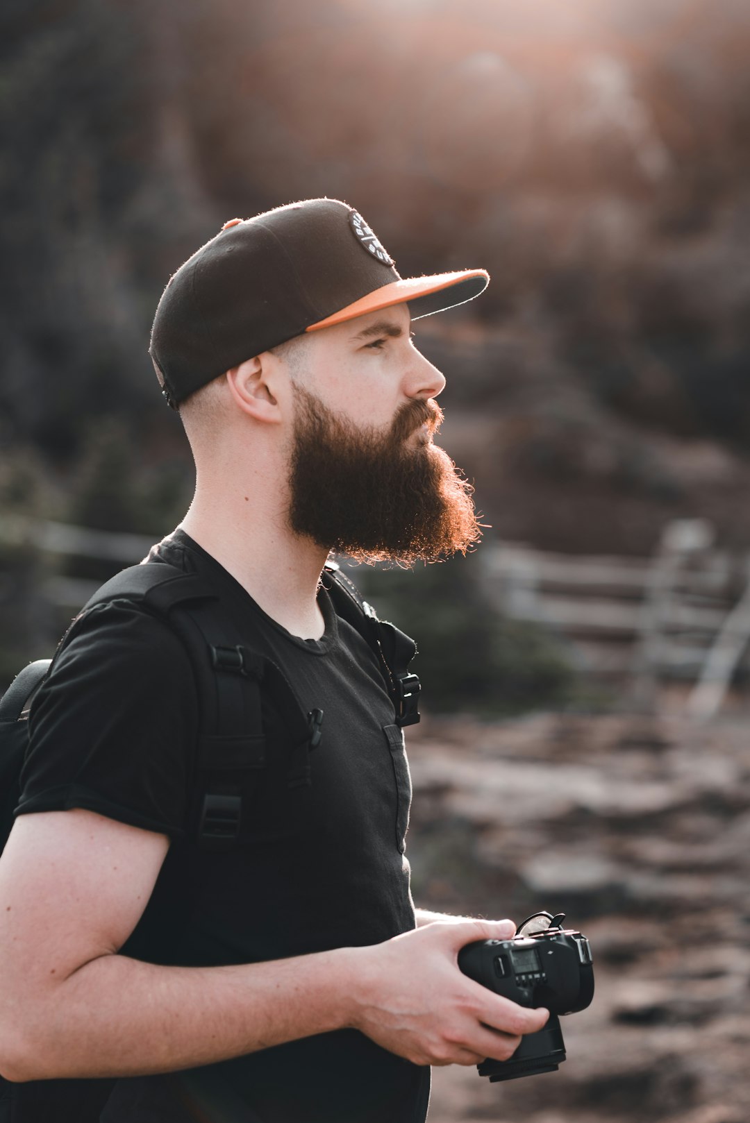 man in black crew neck t-shirt wearing brown baseball cap