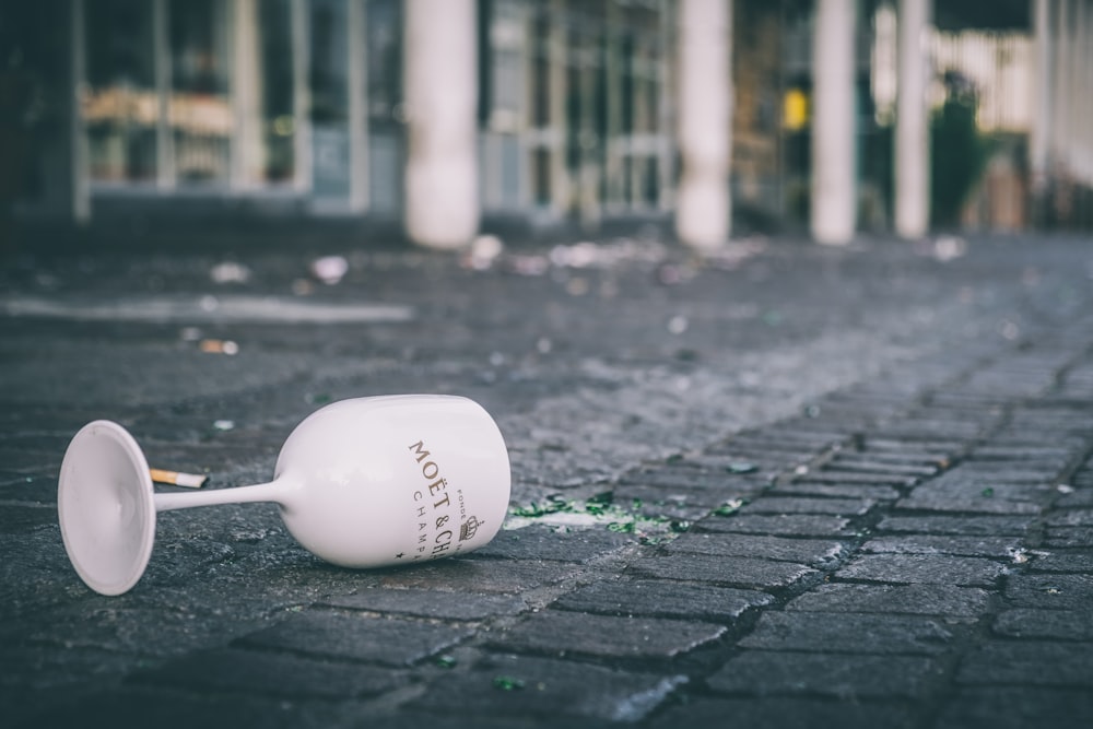 a white cup that is laying on the ground