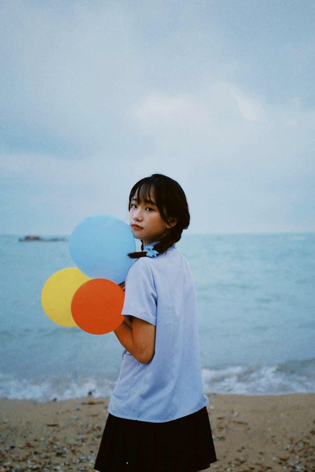 girl in white shirt holding yellow balloon