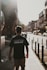 man in black crew neck t-shirt standing on sidewalk during daytime