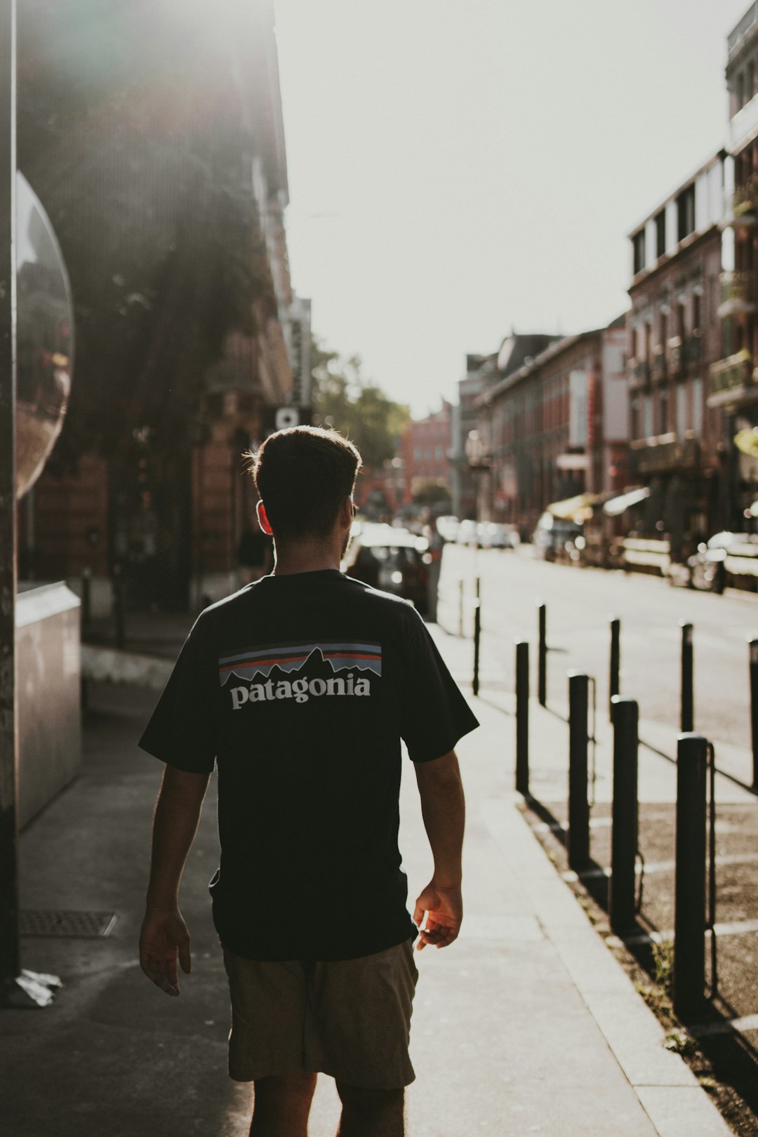 man in black crew neck t-shirt standing on sidewalk during daytime