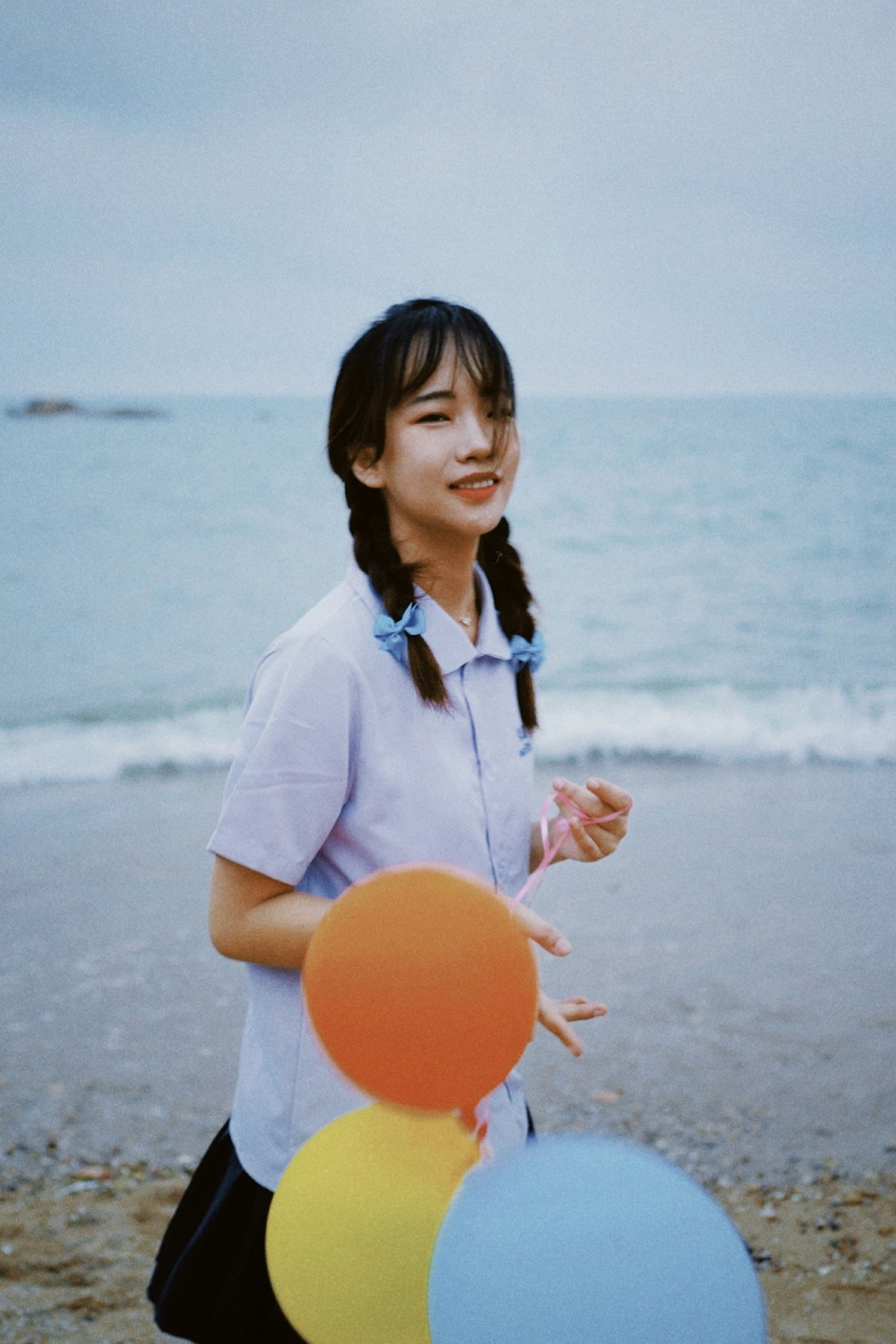 woman in white button up shirt holding orange round ball