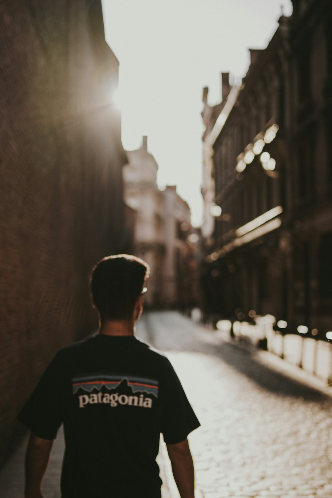 man in black and white crew neck shirt standing in the middle of the street