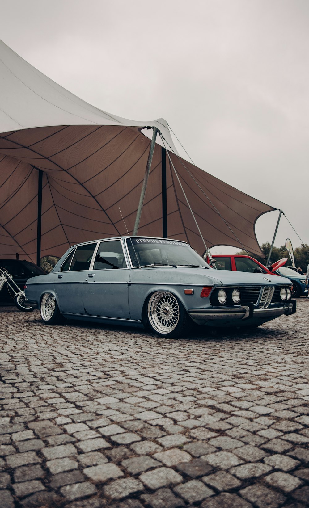 black bmw m 3 coupe parked beside brown wooden wall