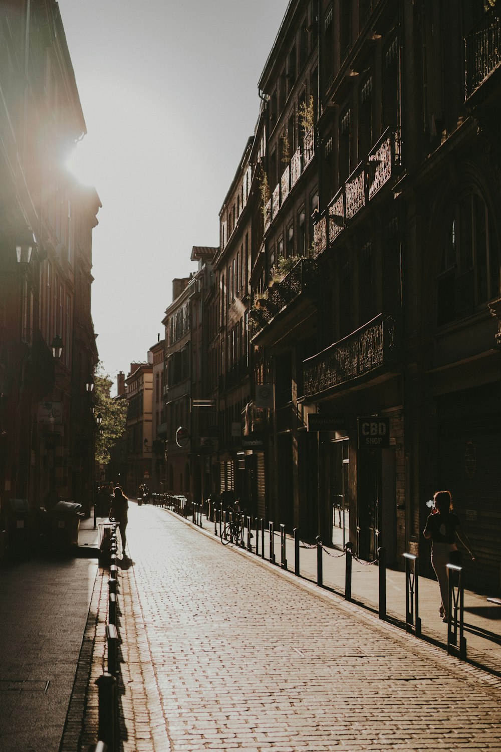 people walking on sidewalk in between buildings during daytime