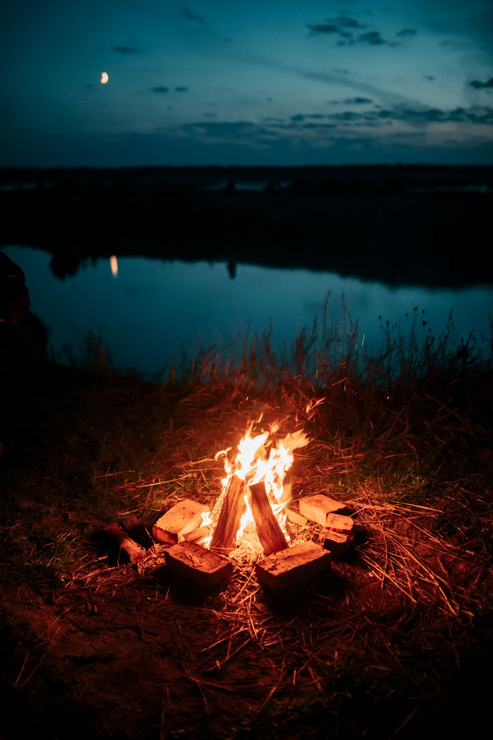 bonfire near lake during night time