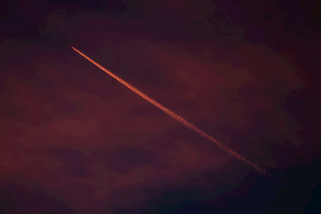 an airplane is flying in the sky at night,
