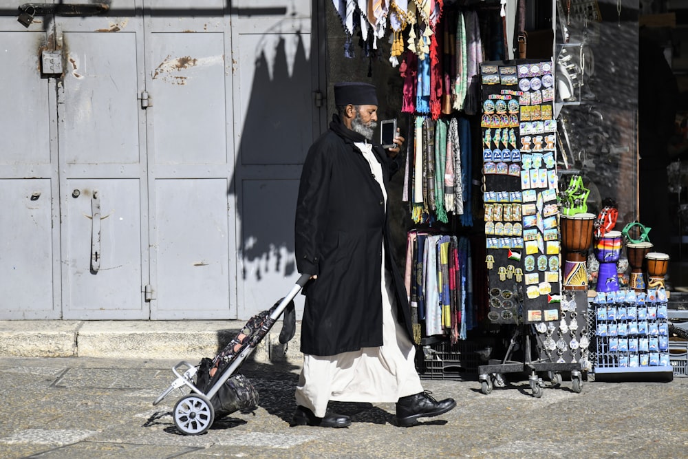 a man walking down a street with a stroller